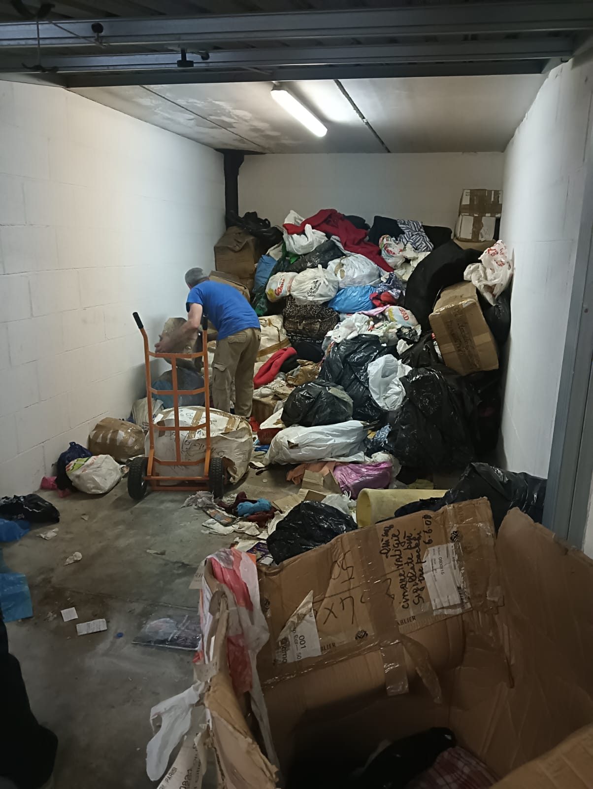 Cantina box auto piena di scatoloni e sacchi prima dello sgombero a Roma